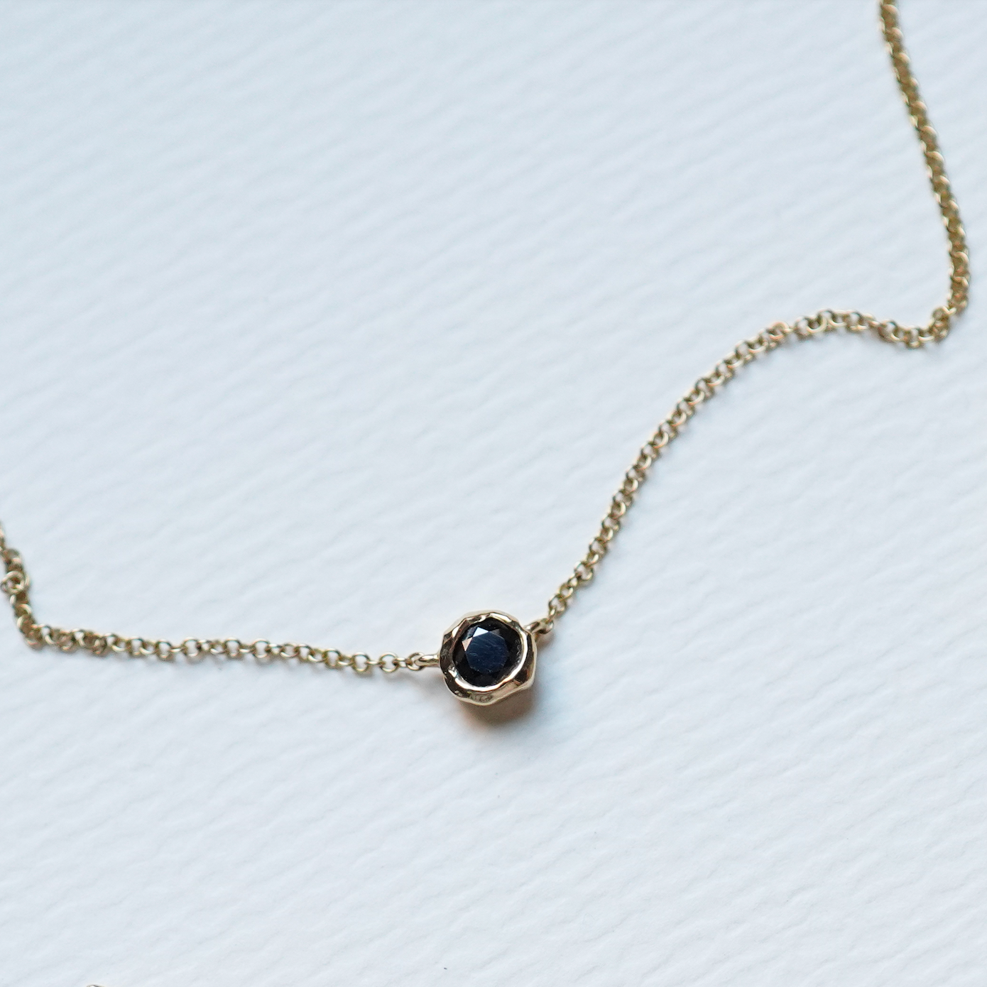 Necklace with a black gemstone pendant on a white background